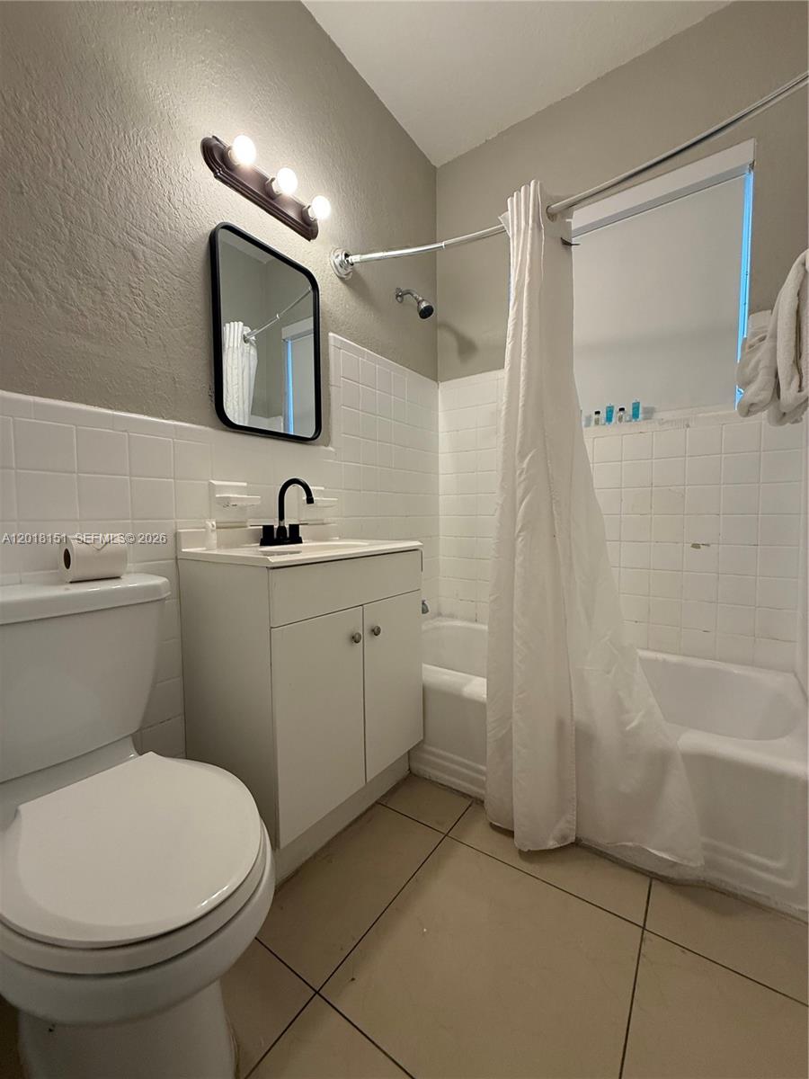 7710 Harding Avenue, Unit 1 Miami Beach, FL 33141 - Photo 1 of 10 a bathroom with a sink a toilet and shower a mirror