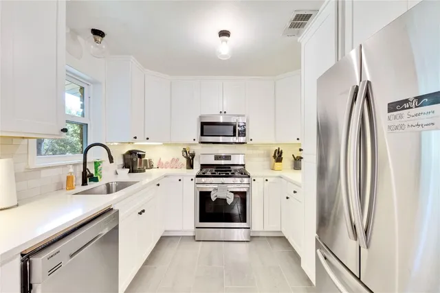 a kitchen with stainless steel appliances a stove sink and refrigerator