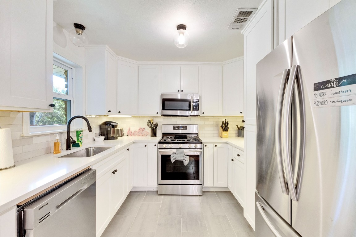 3306 South Pleasant Valley Road Austin, TX 78741 - Photo 12 of 28 a kitchen with stainless steel appliances a stove sink and refrigerator