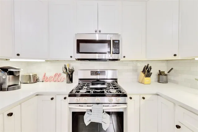 a kitchen with a stove and a white cabinets