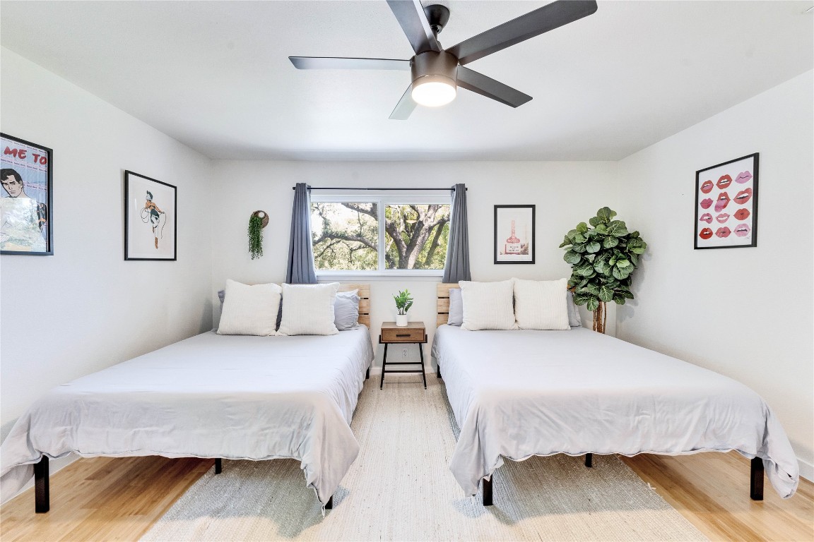 3306 South Pleasant Valley Road Austin, TX 78741 - Photo 18 of 28 a spacious bedroom with a bed painting on wall and two windows