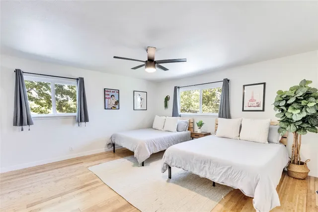 a bedroom with two beds and a potted plant