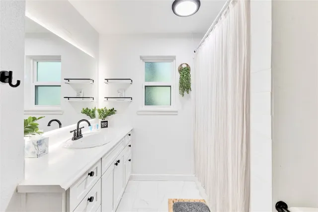 a bathroom with a sink a mirror and a shower