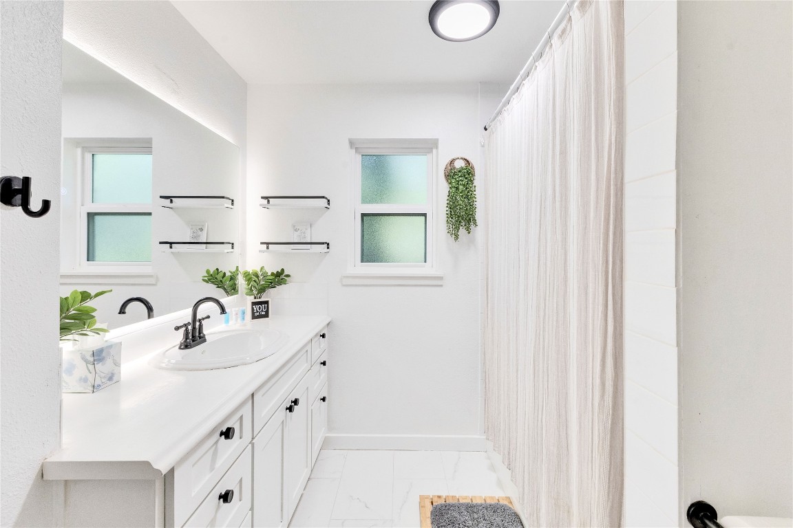 3306 South Pleasant Valley Road Austin, TX 78741 - Photo 25 of 28 a bathroom with a sink a mirror and a shower