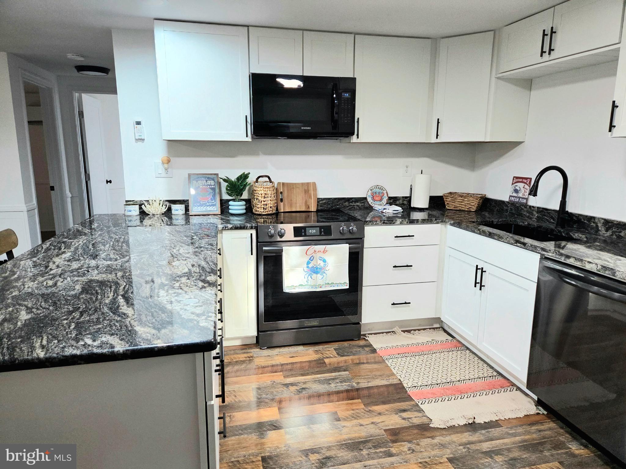 927 Susquehanna Road Madison, MD 21648 - Photo 12 of 26 a kitchen with stainless steel appliances granite countertop a stove a sink and a white cabinets