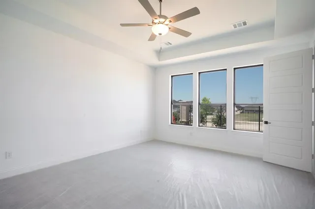 an empty room with a window and a ceiling fan
