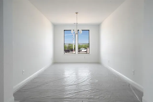 an empty room with windows and ceiling fan
