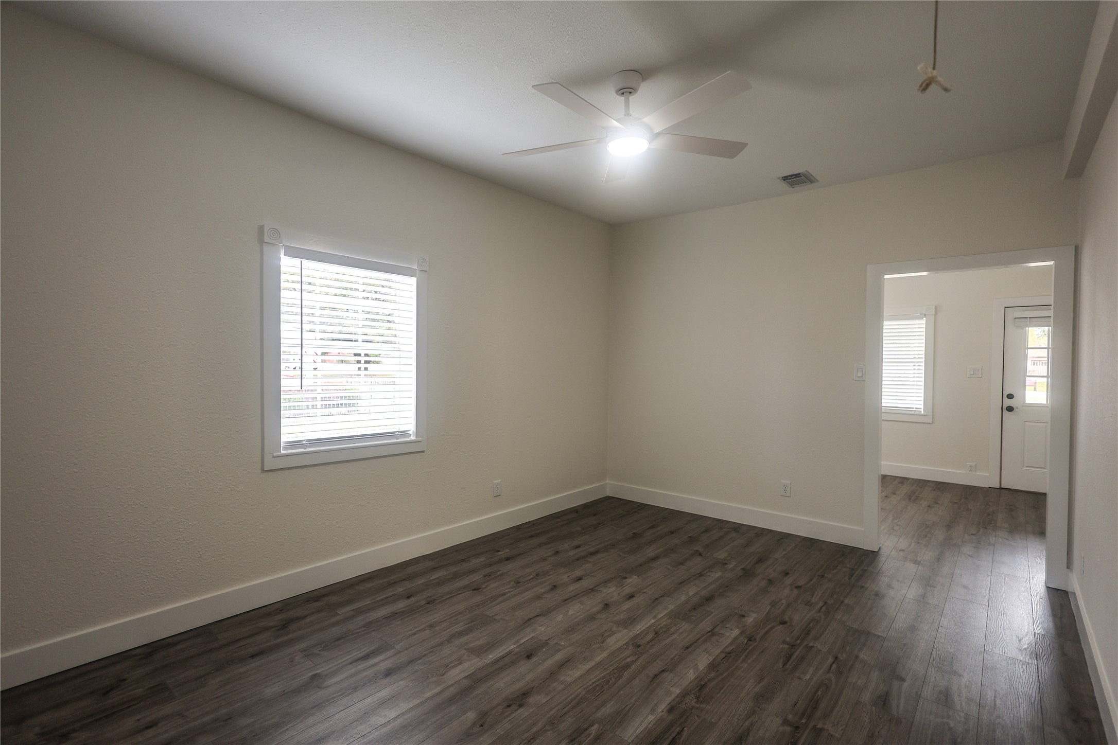 602 Higgins Street Humble, TX 77338 - Photo 11 of 39 an empty room with wooden floor and windows