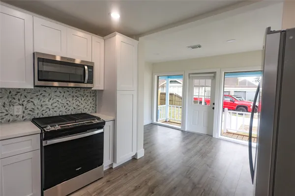 a kitchen with granite countertop wooden cabinets stainless steel appliances and a window