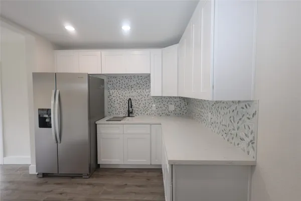 a kitchen with a refrigerator sink and cabinets