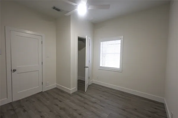 an empty room with wooden floor and window