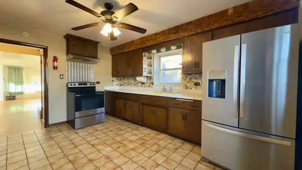 a kitchen with a sink a stove cabinets and a window