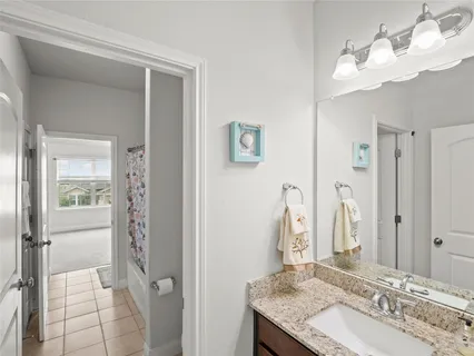 a bathroom with a granite countertop sink a mirror and a shower