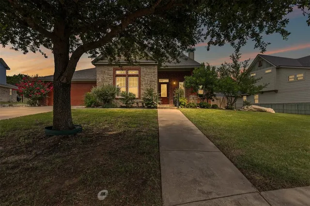 a front view of a house with yard and green space