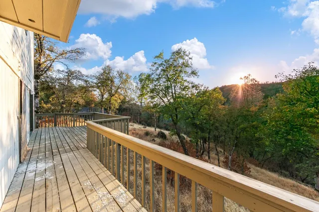 a view of a house with wooden deck and a backyard