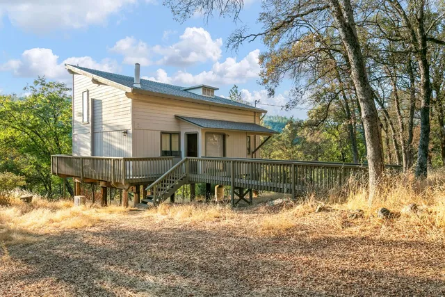 a backyard of a house with table and chairs