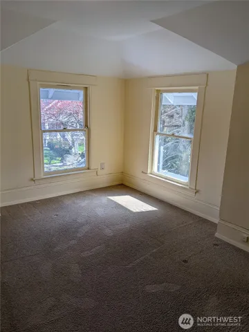 an empty room with windows and closet