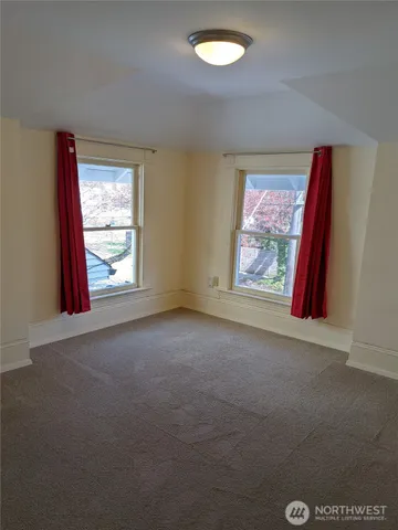 an empty room with windows and closet