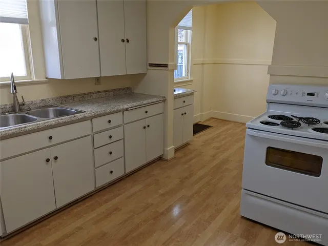 a kitchen with granite countertop white cabinets and white appliances