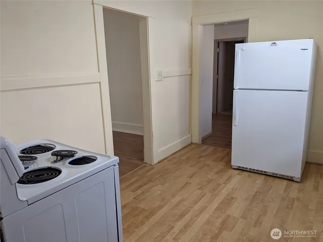 a white refrigerator freezer and a stove sitting inside of a kitchen
