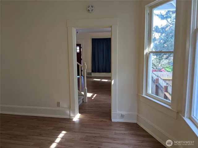 a view of a hallway with wooden floor and a window