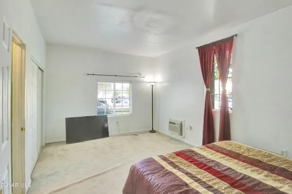 a bedroom with a bed and dresser with mirror