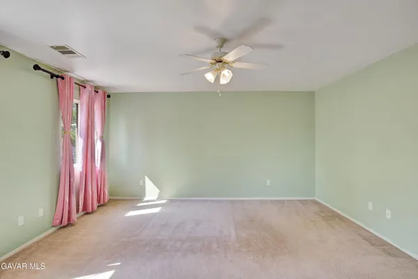 a view of a room with window and ceiling fan