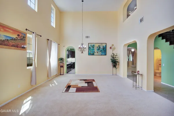 a living room with furniture and a refrigerator