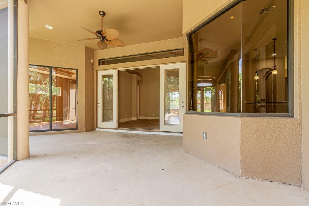 4121 Pine Ridge Road Naples, FL 34119 - Photo 23 of 35 a view of a hallway with wooden floor and chandelier