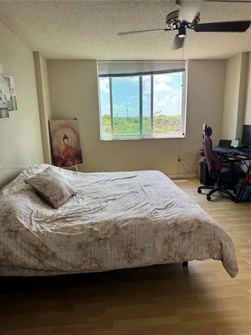 a bedroom with a bed wooden floor and window