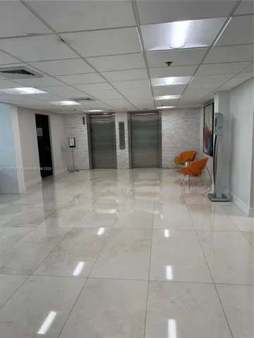 a view of a room with gym equipment and wooden floor