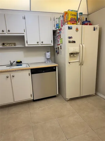 a kitchen with granite countertop white cabinets and sink