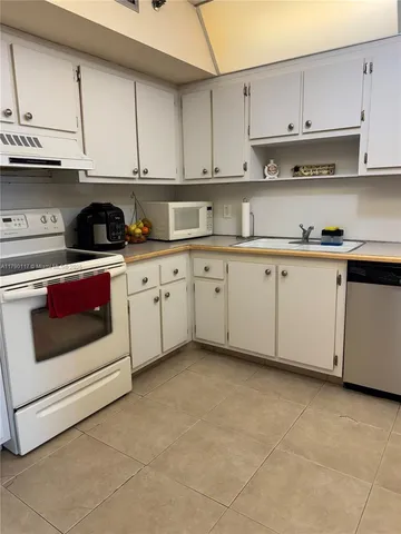 a kitchen with stainless steel appliances granite countertop a stove a white cabinets and granite counter tops