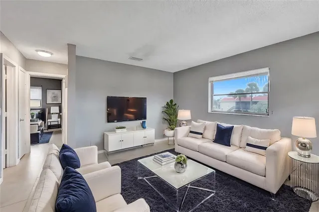 a living room with furniture a rug and a flat screen tv