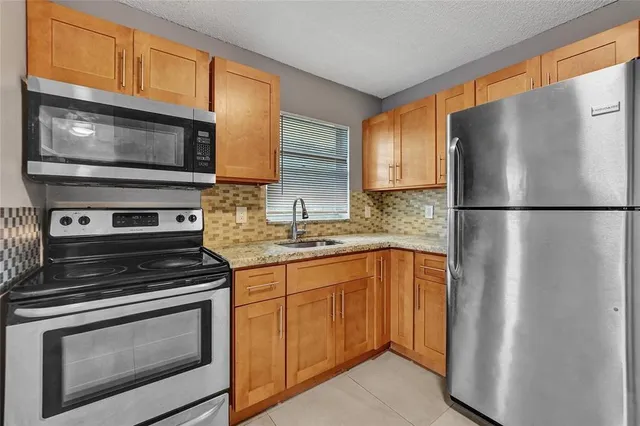 a kitchen with stainless steel appliances granite countertop a refrigerator stove and microwave