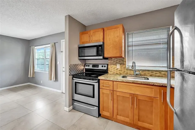 a kitchen with stainless steel appliances granite countertop a stove top oven microwave and refrigerator