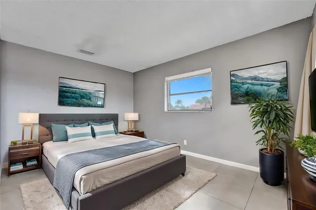 a bedroom with a large bed and a potted plant