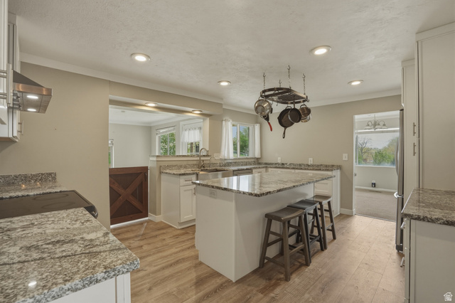 500 North 800 East Springville, UT 84663 - Photo 11 of 51 Kitchen featuring light wood finished floors, white cabinets, a breakfast bar area, light stone counters, and recessed lighting