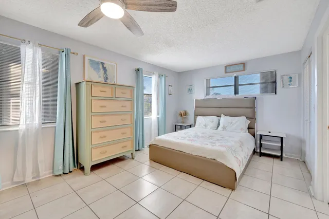 a bedroom with a bed a rug and a flat screen tv
