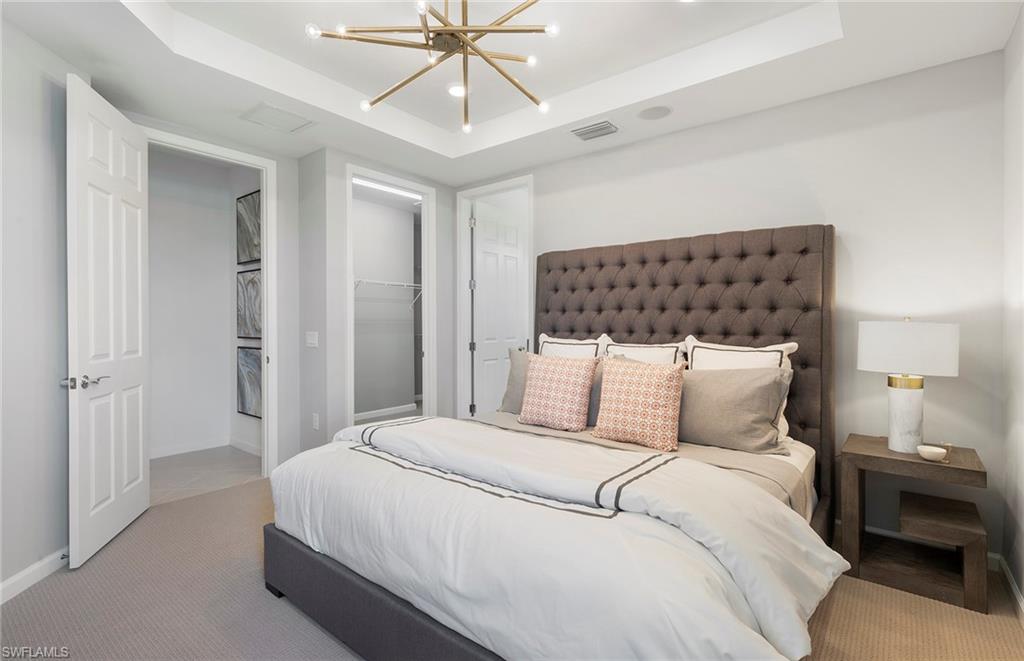 6426 Memorial Lane Ave Maria, FL 34142 - Photo 18 of 38 a bedroom with a bed and a chandelier