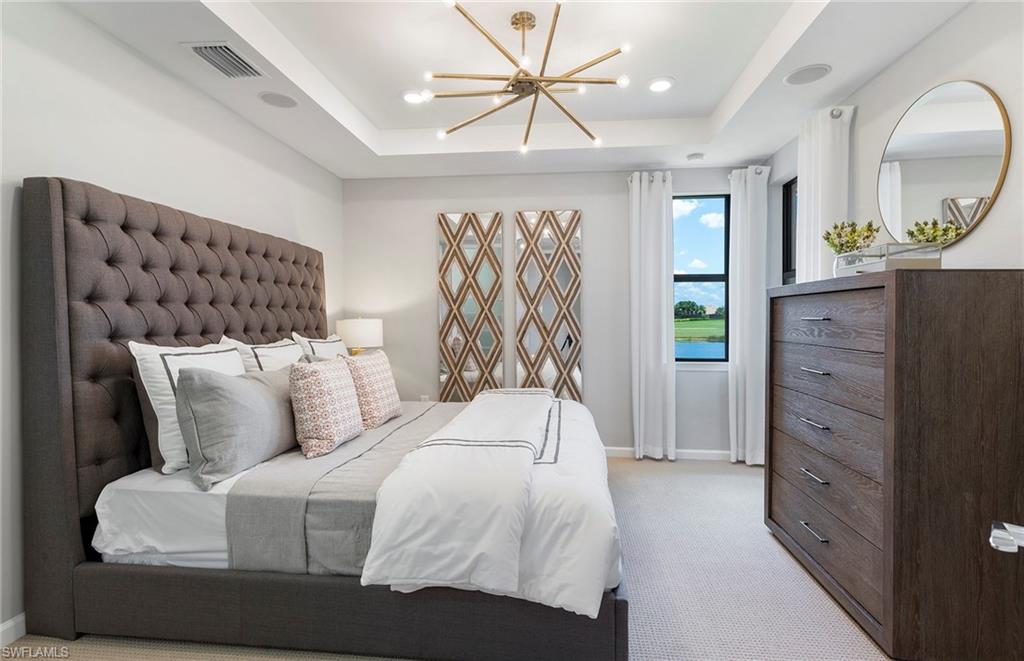 6426 Memorial Lane Ave Maria, FL 34142 - Photo 19 of 38 a bedroom with a bed and a chandelier