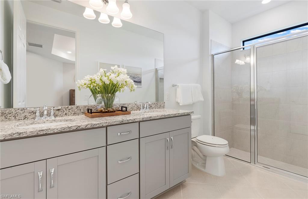 6426 Memorial Lane Ave Maria, FL 34142 - Photo 20 of 38 a bathroom with a granite countertop sink a toilet and a mirror