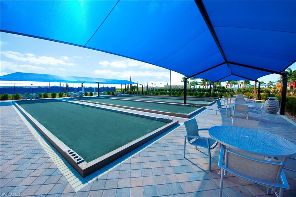 6426 Memorial Lane Ave Maria, FL 34142 - Photo 33 of 38 a view of a tennis ground with a table and chairs under an umbrella
