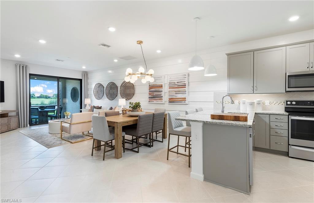 6426 Memorial Lane Ave Maria, FL 34142 - Photo 10 of 38 a large kitchen with kitchen island a white counter space a sink appliances and cabinets