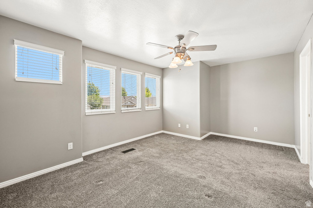 3215 West 450 North West Point, UT 84015 - Photo 14 of 40 Expansive room featuring plush grey carpeting, light grey wall paint, and multiple windows with blinds