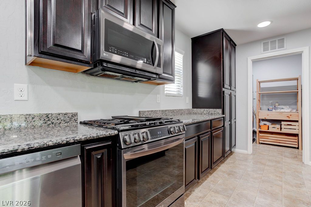 7724 Vibrant Thread Court Las Vegas, NV 89149 - Photo 10 of 43 Granite counters and stainless steel appliances outfit this functional culinary space.