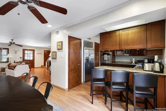 a kitchen with stainless steel appliances granite countertop furniture wooden floor and a window