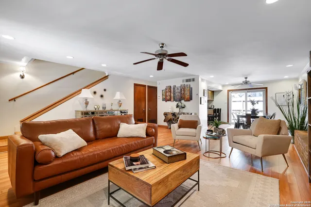 a living room with furniture a ceiling fan and a rug