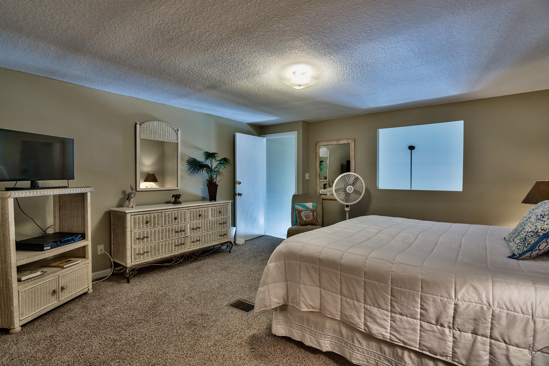 595 Eastern Lake Road, Unit 108 Santa Rosa Beach, FL 32459 - Photo 17 of 26 a bedroom with a bed and a flat tv screen on dresser