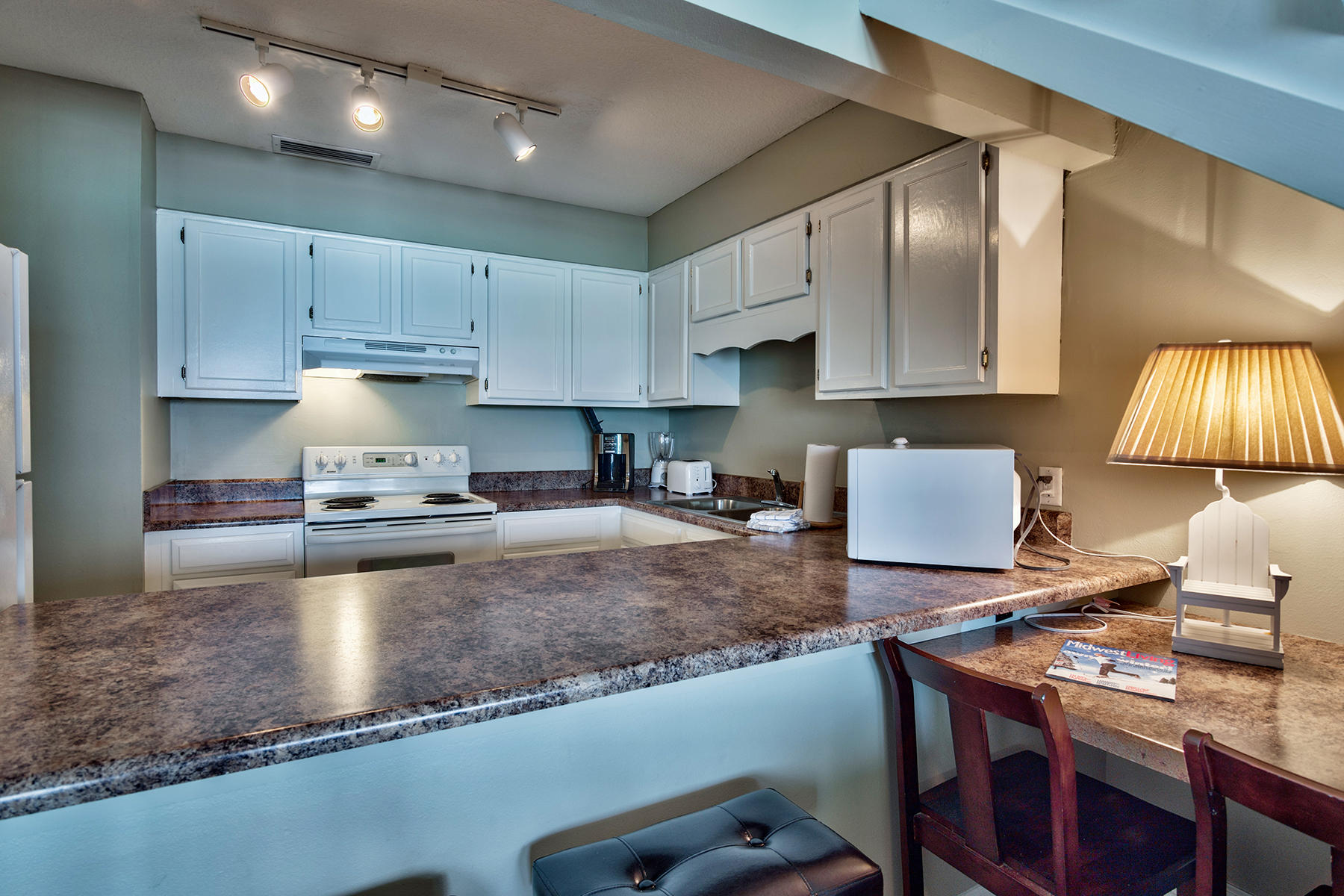 595 Eastern Lake Road, Unit 108 Santa Rosa Beach, FL 32459 - Photo 5 of 26 a kitchen with kitchen island granite countertop a table chairs sink and cabinets